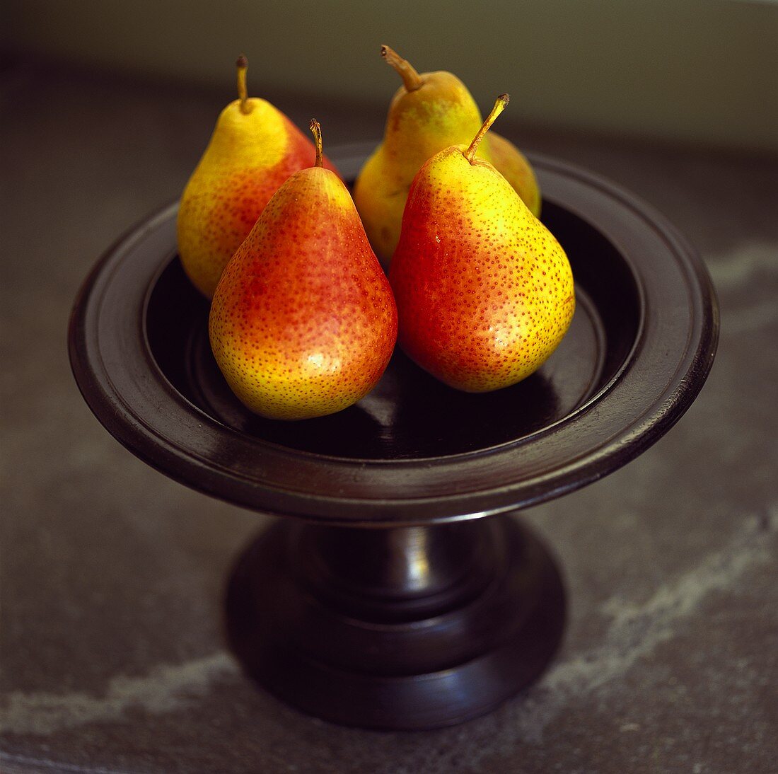 Four pears on a pedestal stand 