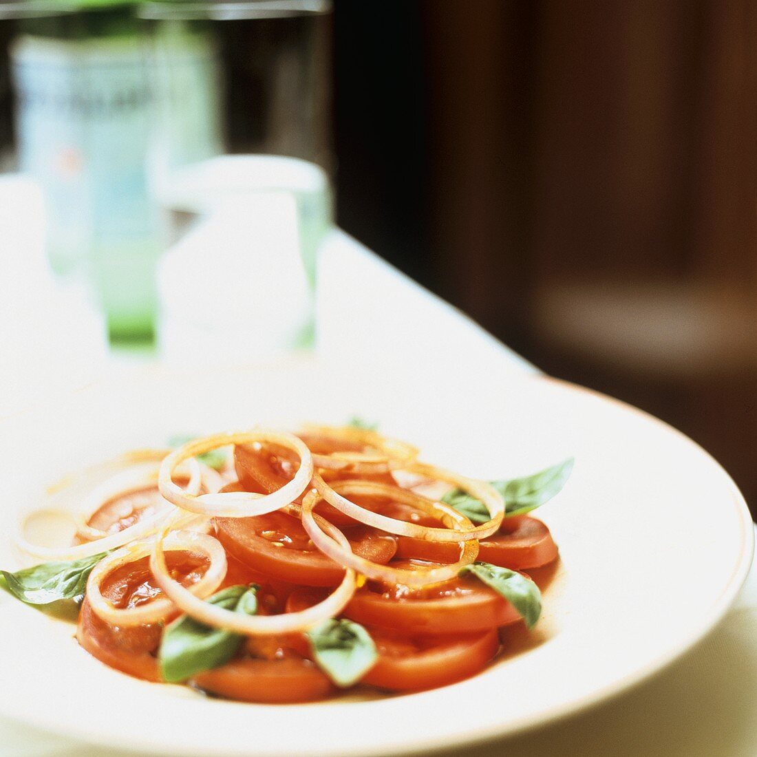 Tomatensalat mit Zwiebelringen und Basilikum