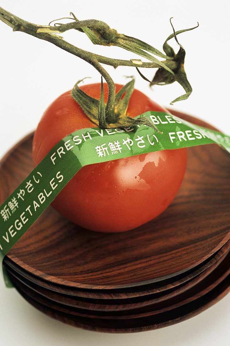 Tomate auf Holzschälchen mit 'fresh vegetables' Aufkleber