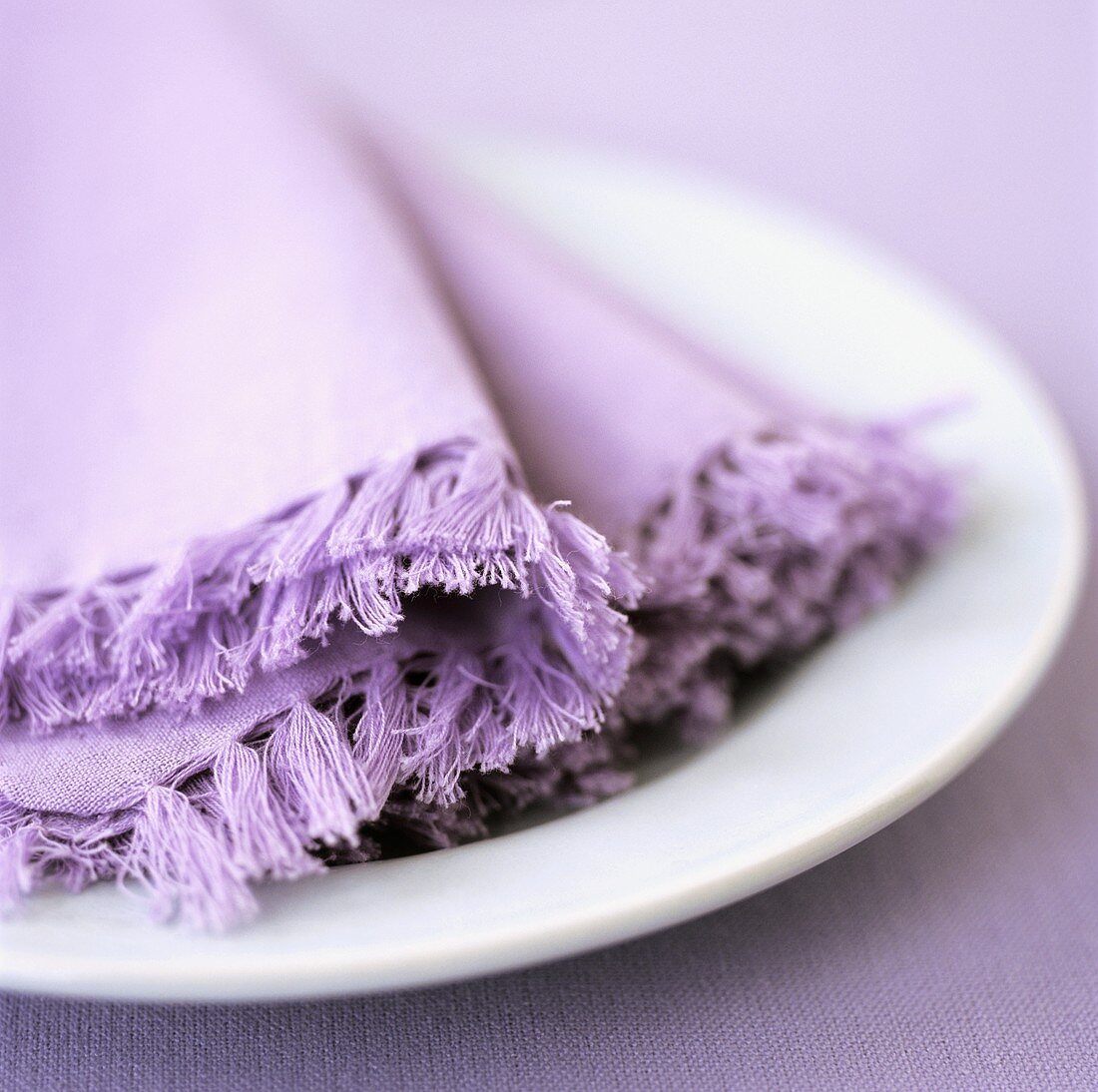 White plate with purple fabric napkins