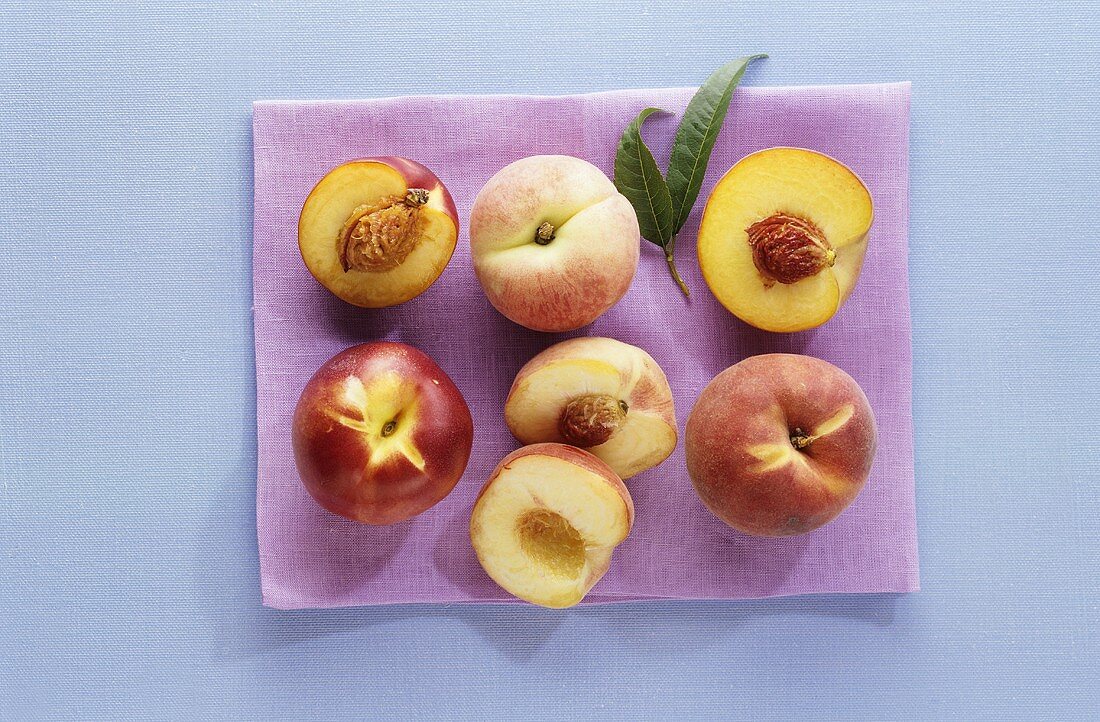 Pfirsiche und Nektarine, ganz und halbiert