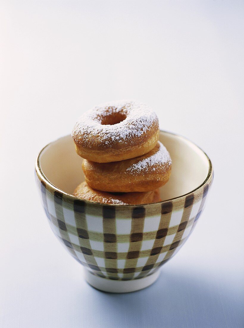 Doughnuts with icing sugar in a bowl