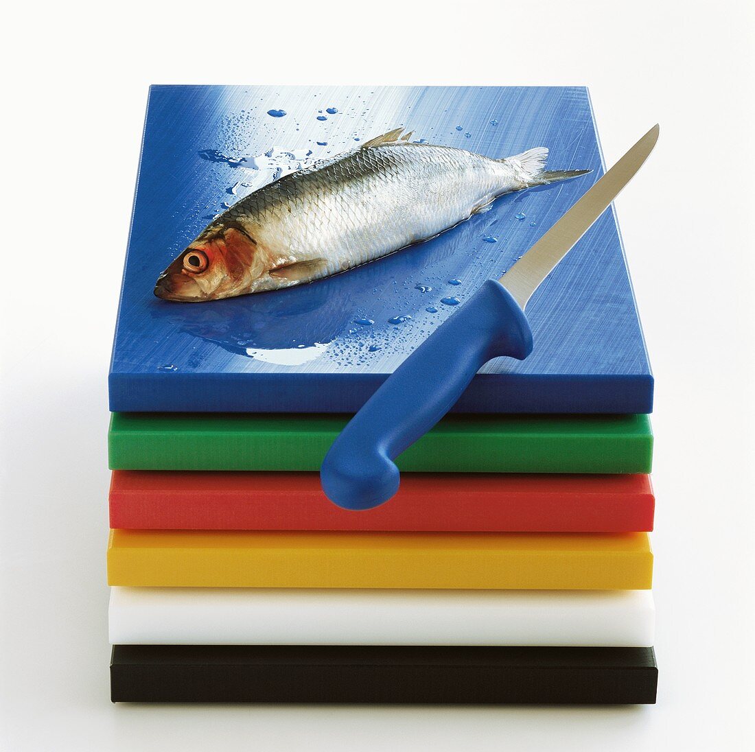 A herring with knife on blue board