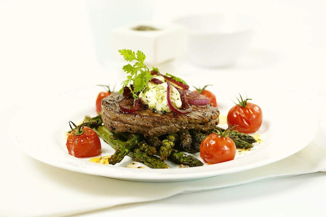 Beef fillet on green asparagus with cherry tomatoes