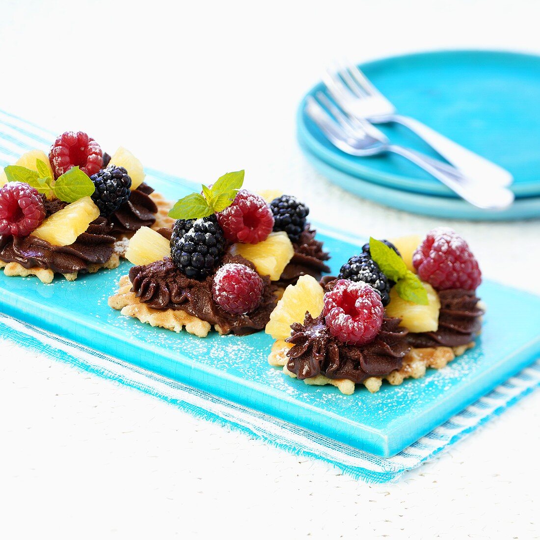 Waffle biscuits topped with chocolate cream and fruit