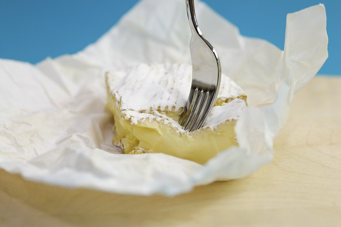 Camembert in Papier mit Gabel