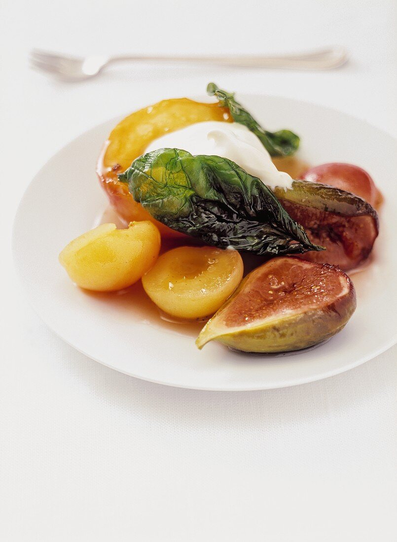 Obstdessert mit Sirup, Schlagsahne und frittiertem Basilikum