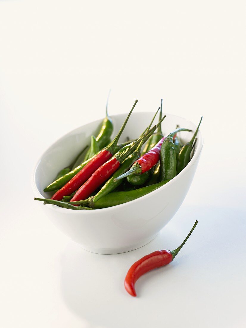 Red and green chili peppers in a white bowl