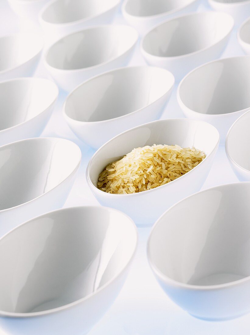 Long-grain rice in a bowl among lots of empty bowls