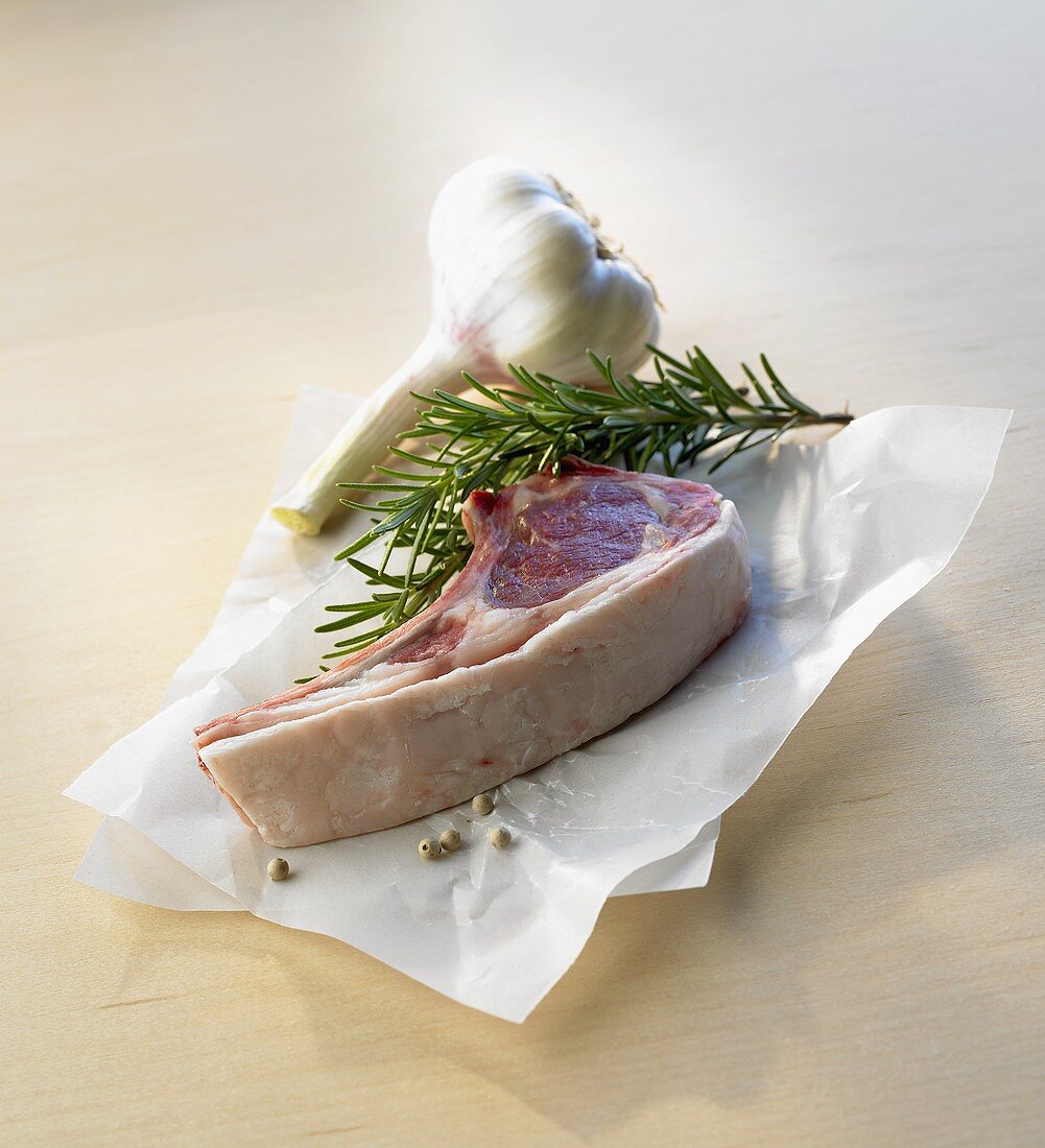 A lamb cutlet, rosemary and garlic bulb
