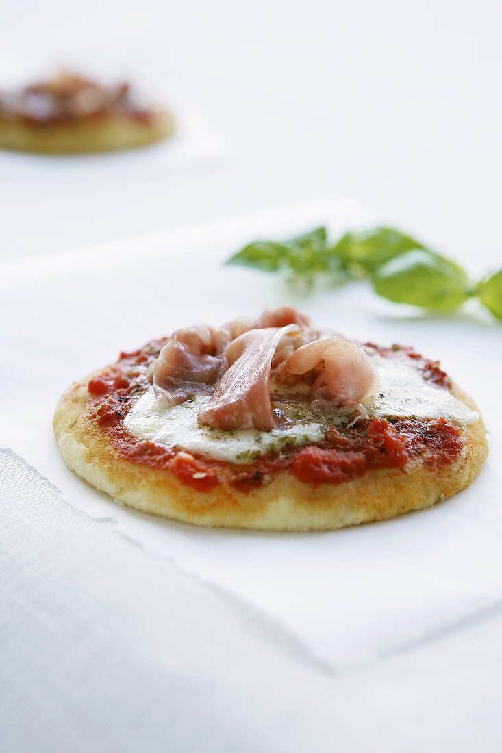 Minipizza mit Tomate, Käse und Schinken