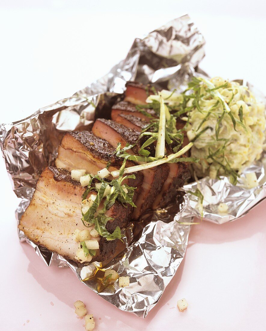Roast pork with salad on aluminium foil
