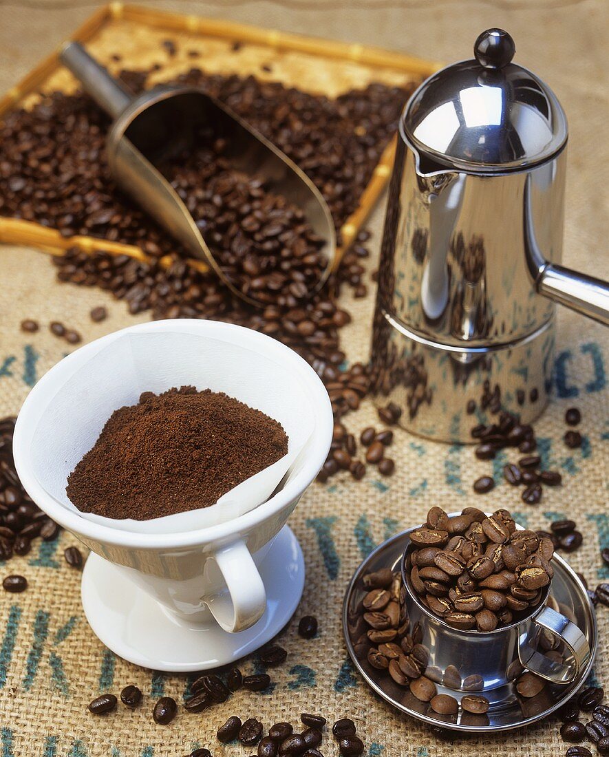 Stillleben mit Kaffeebohnen, Kaffeepulver und Kaffeekanne