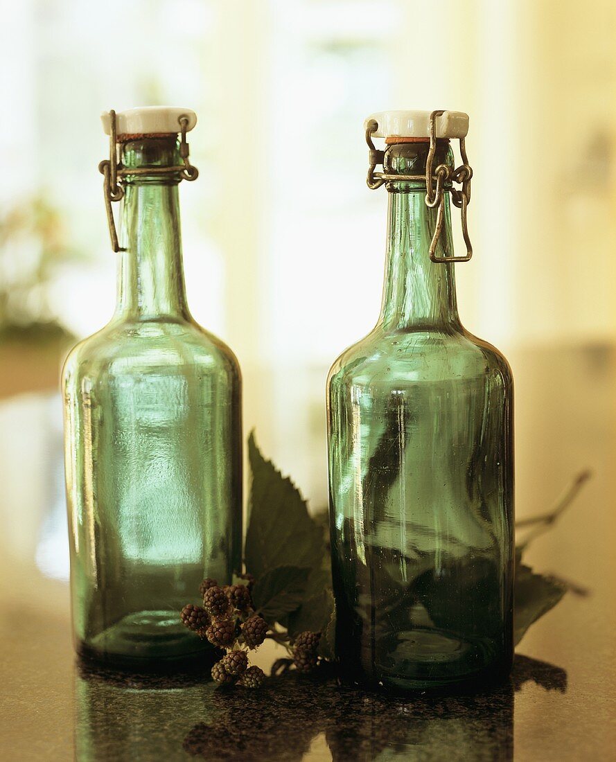 Green flip-top bottles and unripe blackberries