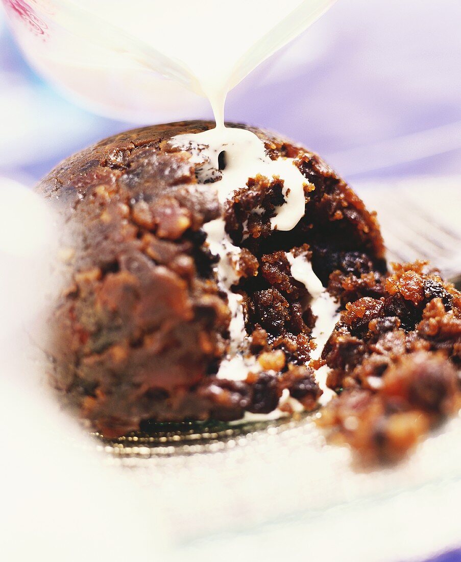 Englischer Christmas Pudding mit Sahne begiessen