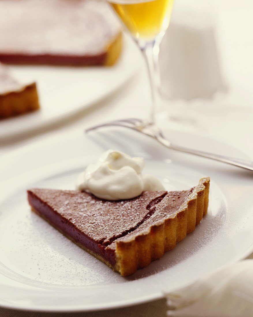 A piece of chocolate tart with cream