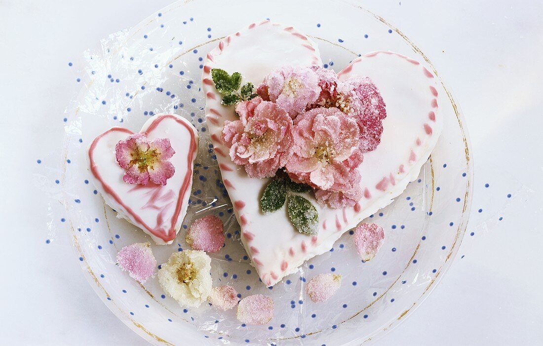 Zwei Herzförmige Torten mit gezuckerten Rosenblüten