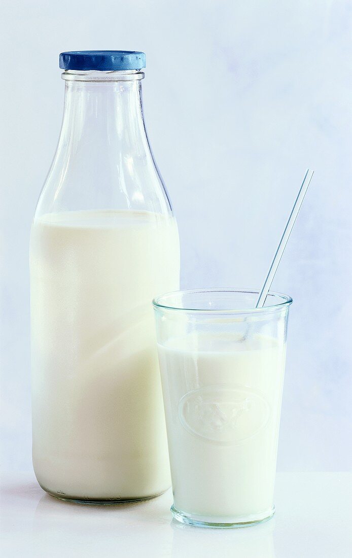 Milch in Flasche und im Glas mit Trinkhalm