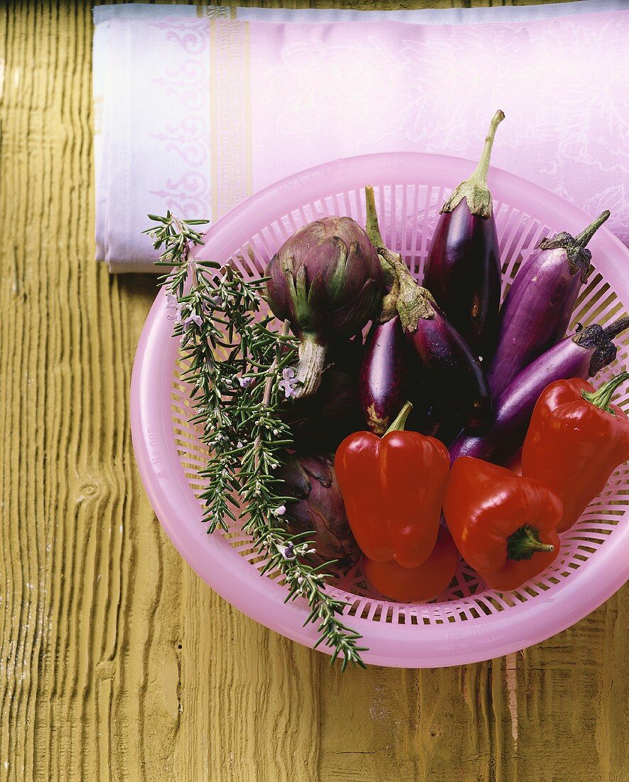 Still life with aubergines, peppers and rosemary
