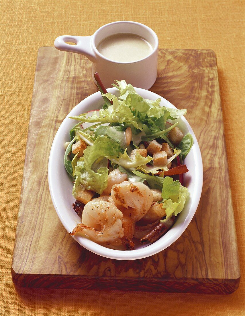 Salad leaves with shrimps, croutons and salad dressing