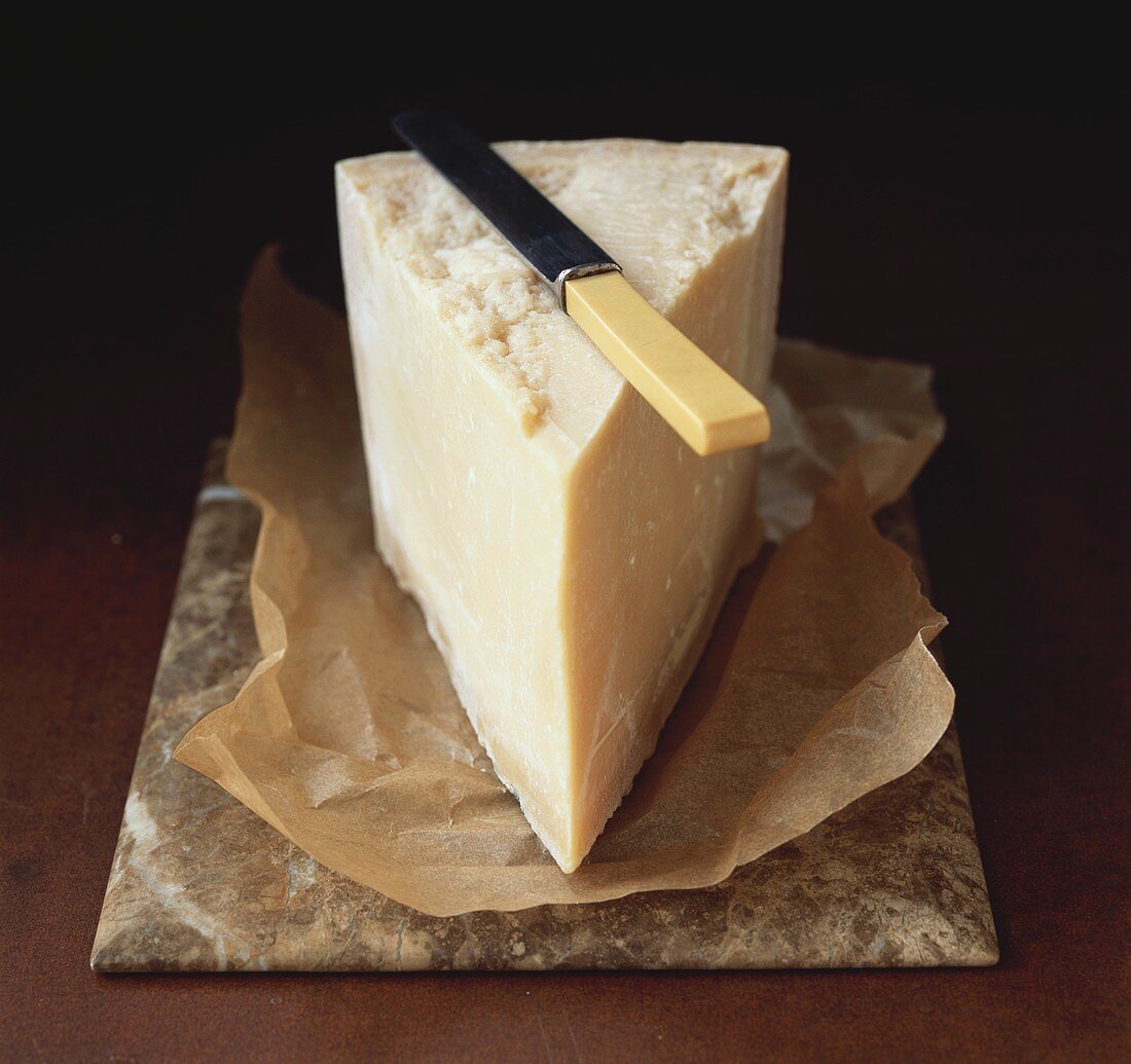 A piece of Parmesan cheese with knife