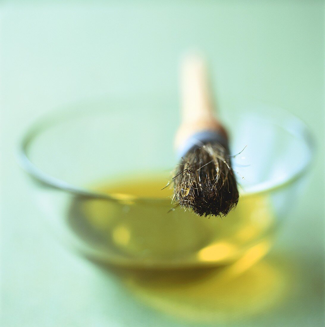 Schälchen mit Olivenöl und Pinsel
