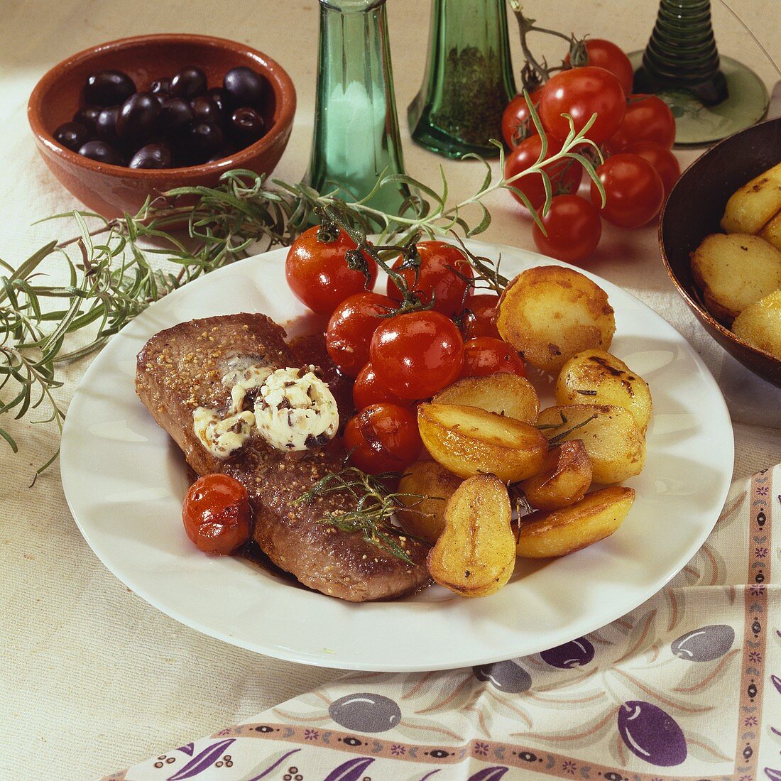 Lamb steak with olive butter, roast potatoes & cherry tomatoes