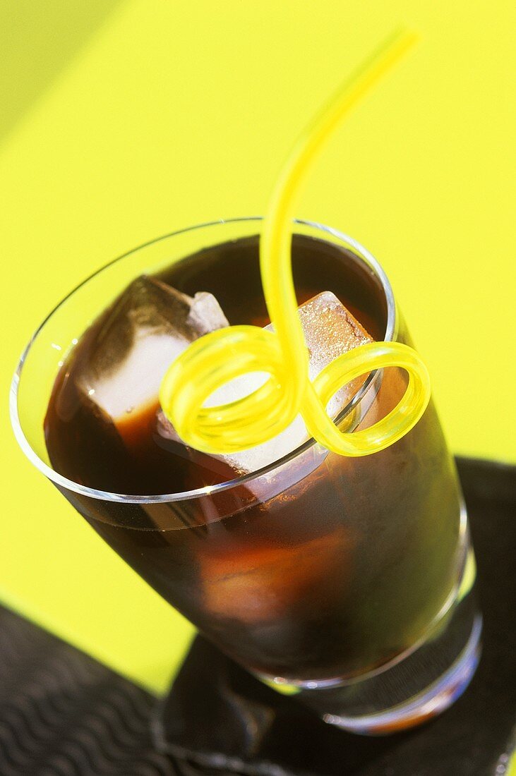 Cola with ice cubes and straw