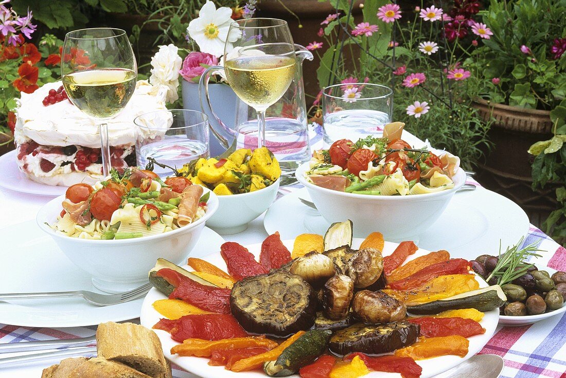 Laid table with appetisers and cake in the open air