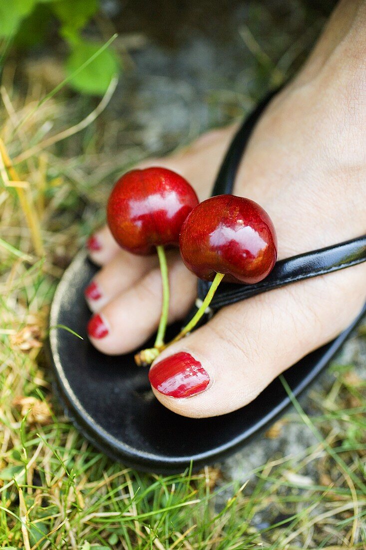 Red toenails with a pair of cherries