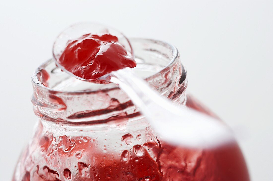 A spoonful of raspberry jelly on a jar