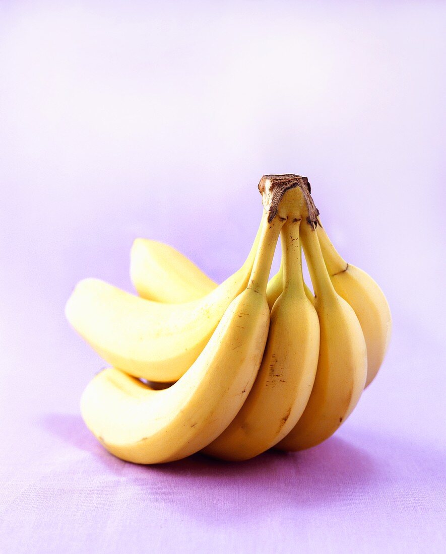 Five bananas on purple background