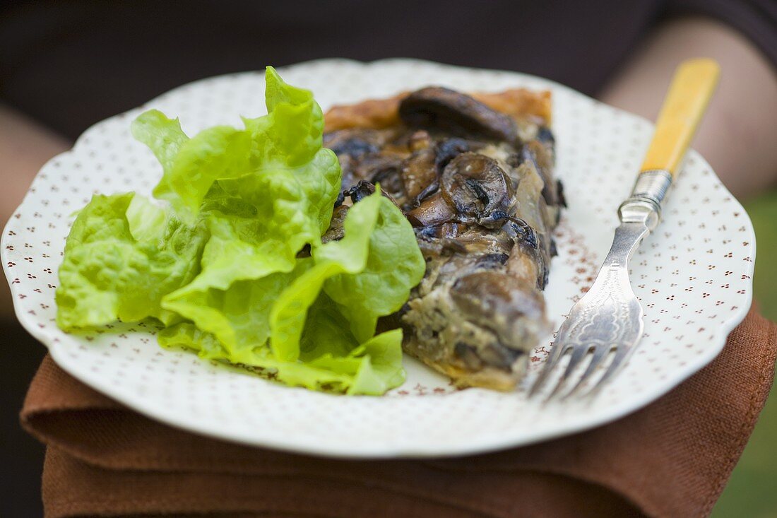 A piece of mushroom tart with lettuce