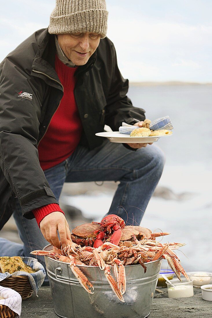 A man reaching for a crab at a picnic