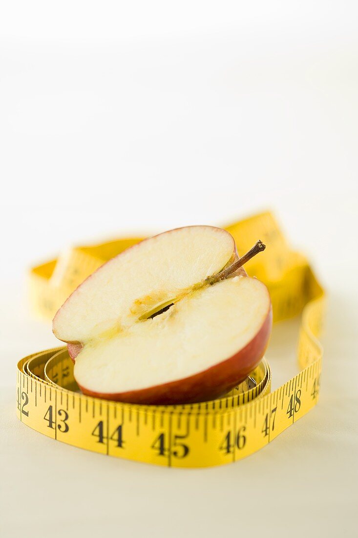 A tape measure around half an apple