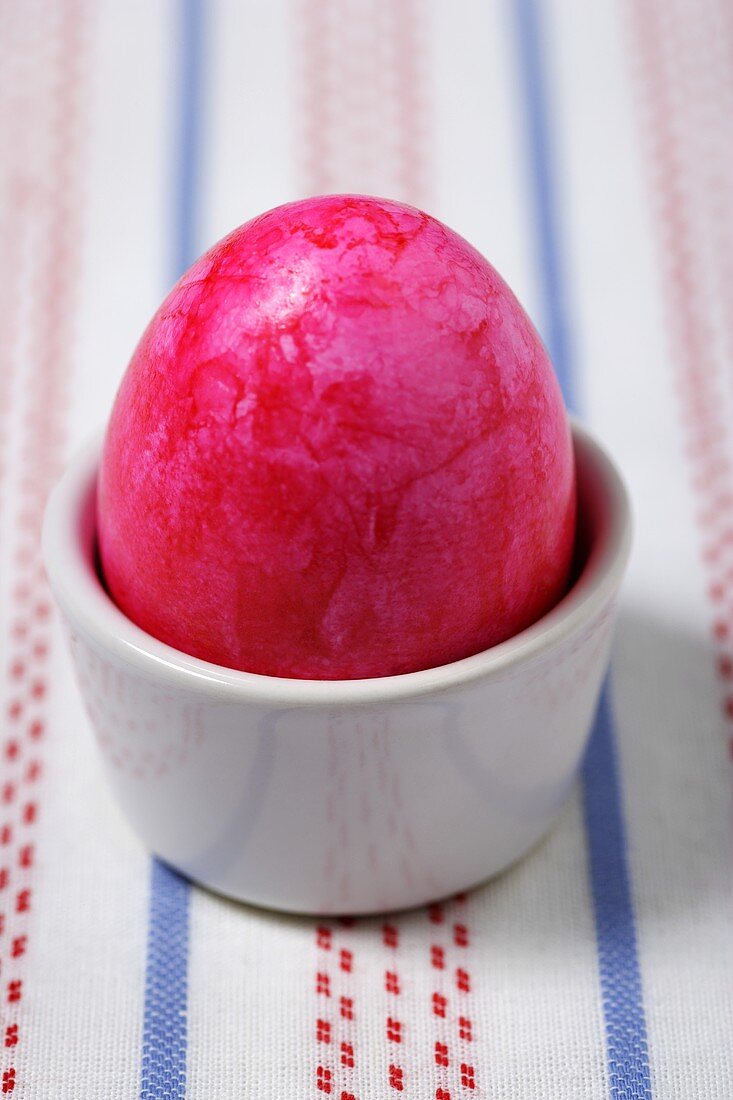 A pink Easter egg in eggcup