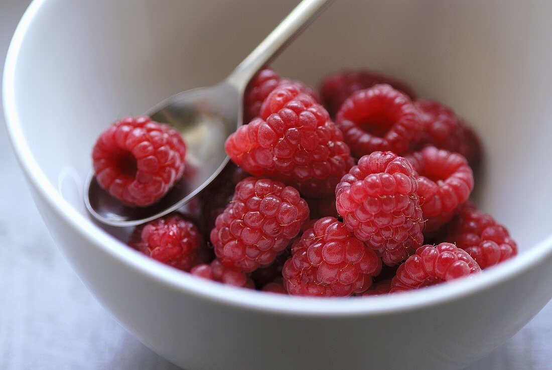 Fresh raspberries in a dish with spoon