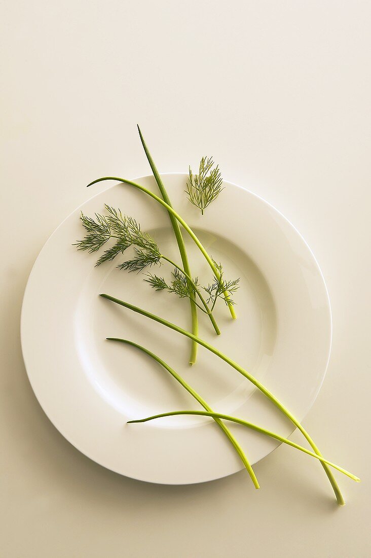 Chives and dill scattered over a plate