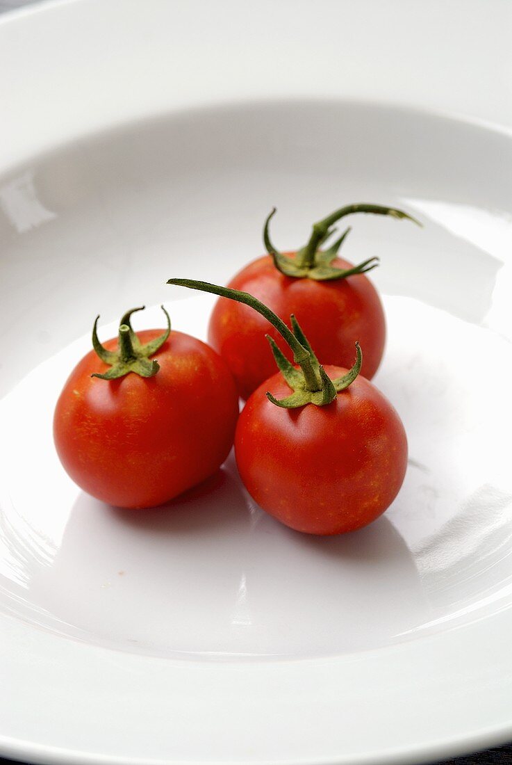 Three tomatoes in a deep plate