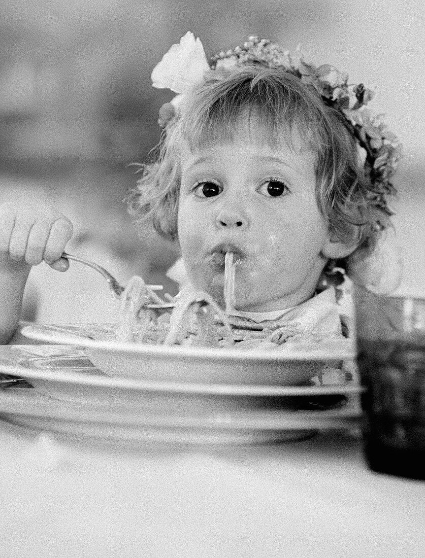 Small girl eating spaghetti