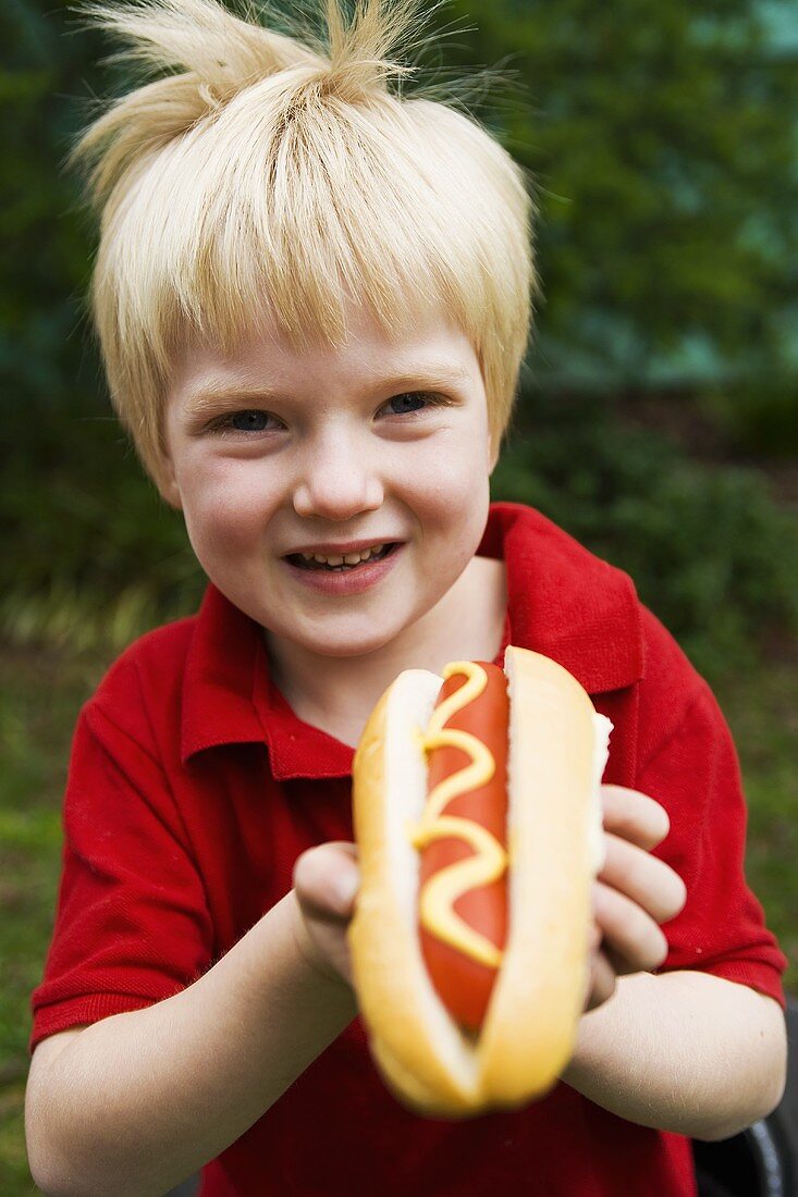 Kleiner Junge mit einem Hot Dogs mit Senf