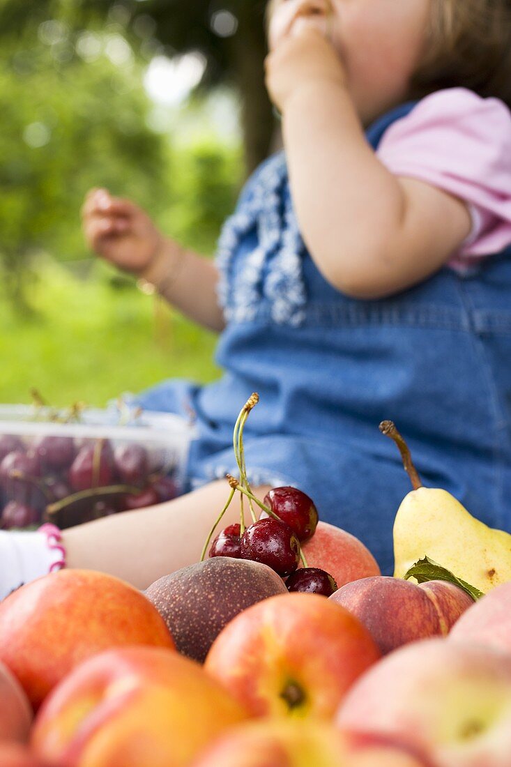 Gemischtes Obst mit Mädchen im Hintergrund