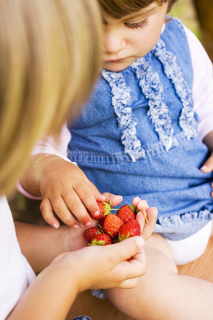 Kinder halten Erdbeeren in der Hand