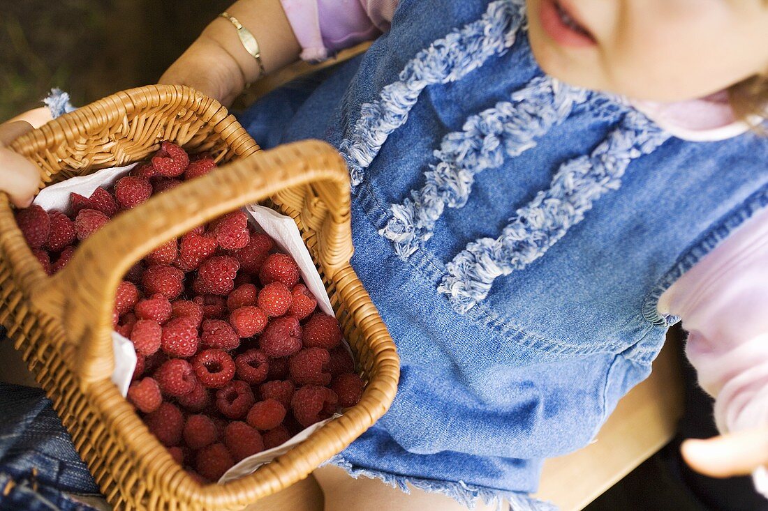 Children holding a basket of raspberries
