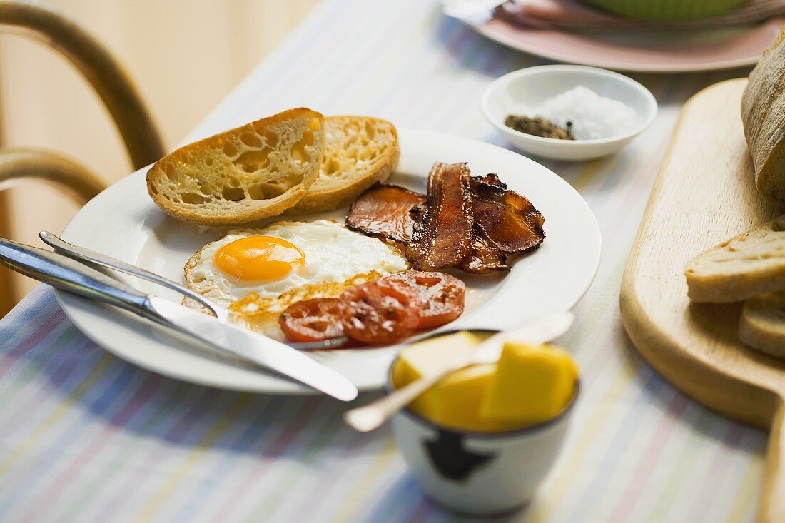 Englisches Frühstück mit Spiegelei, Speck und Tomaten