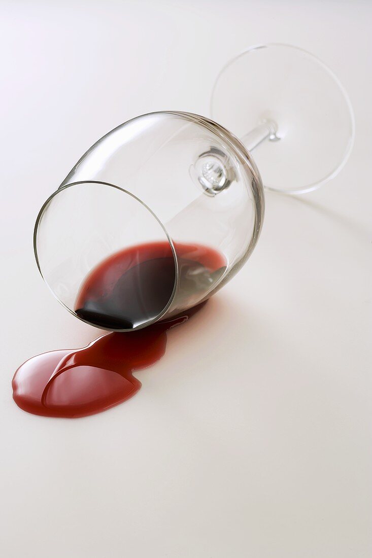 A glass of red wine on its side