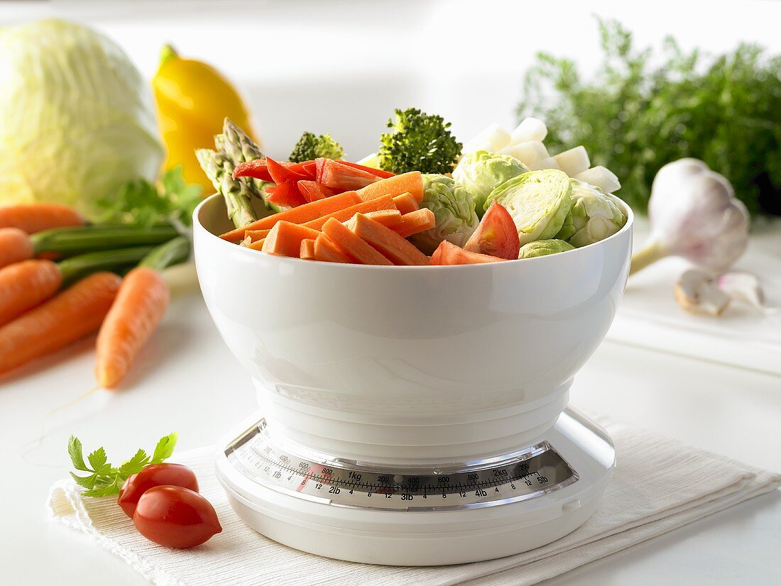 Assorted vegetables on kitchen scales