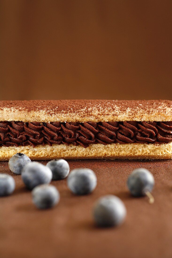 Eclair with chocolate cream filling and blueberries
