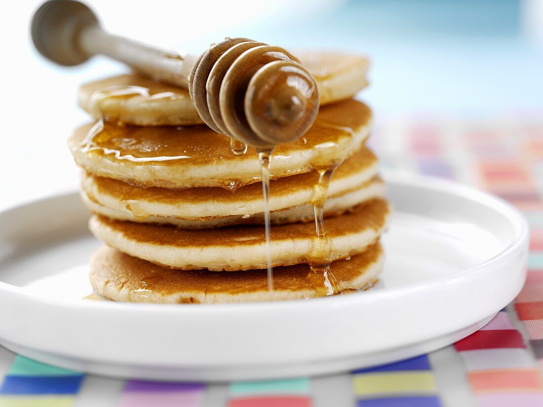 Pancakes with honey and honey dipper