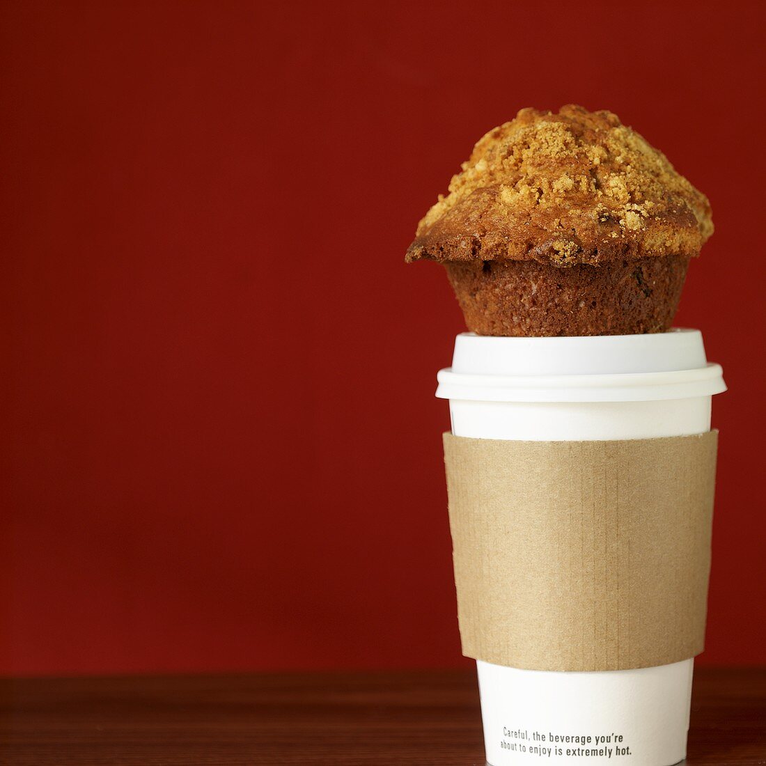 Ein Muffin auf einem Kaffeebecher